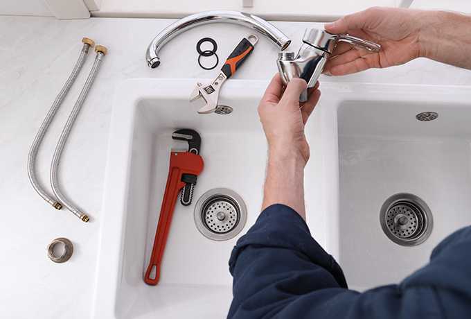 plumber fixing a hand basing in kitchen