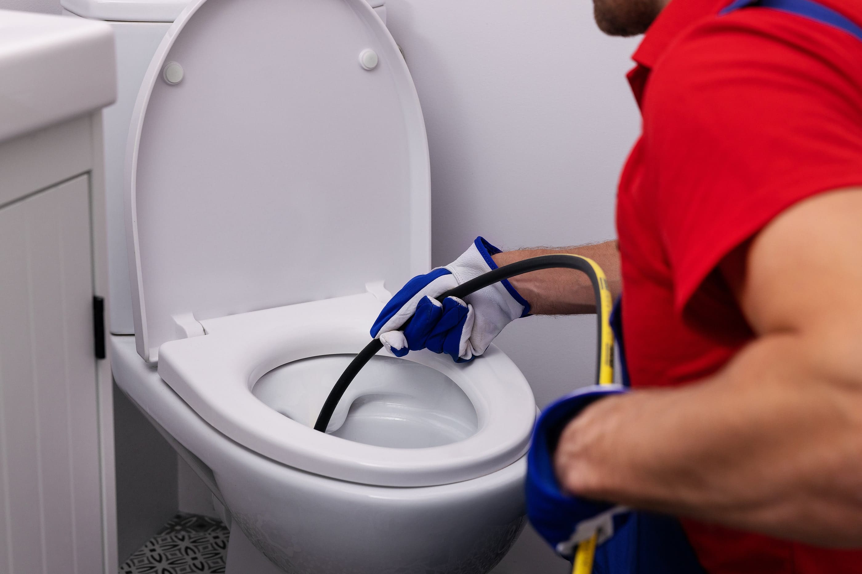 bigstock-Plumber-Unclogging-Blocked-Toi-465375203-min