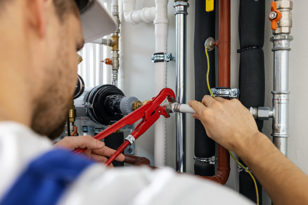 Plumber working with pipelines tighten plumbing fittings